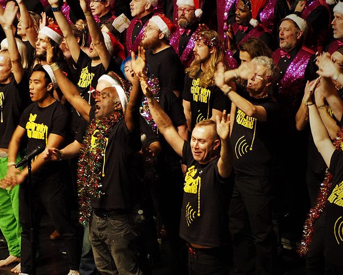 The Choir with No Name at Christmas with their hands in the air