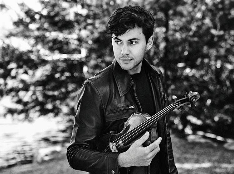 Black & white photo of Benjamin Beilman holding his violin. Photo by Sophie Zhai.