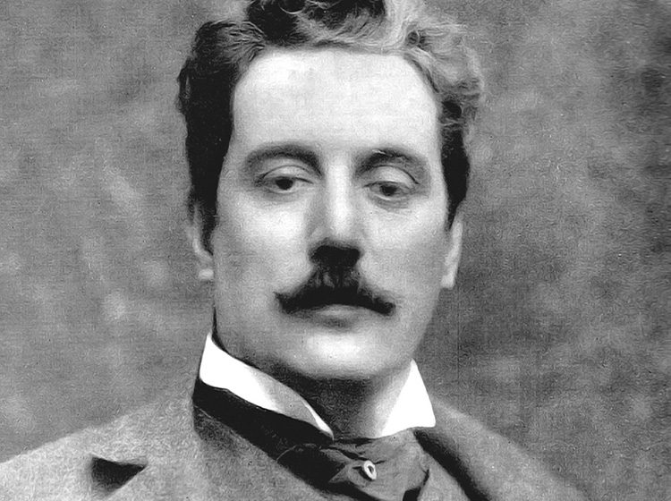 Black & white portrait photo of Puccini looking directly at the camera