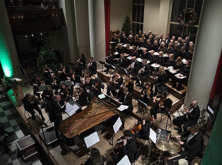 Orchestra and choir performing on stage