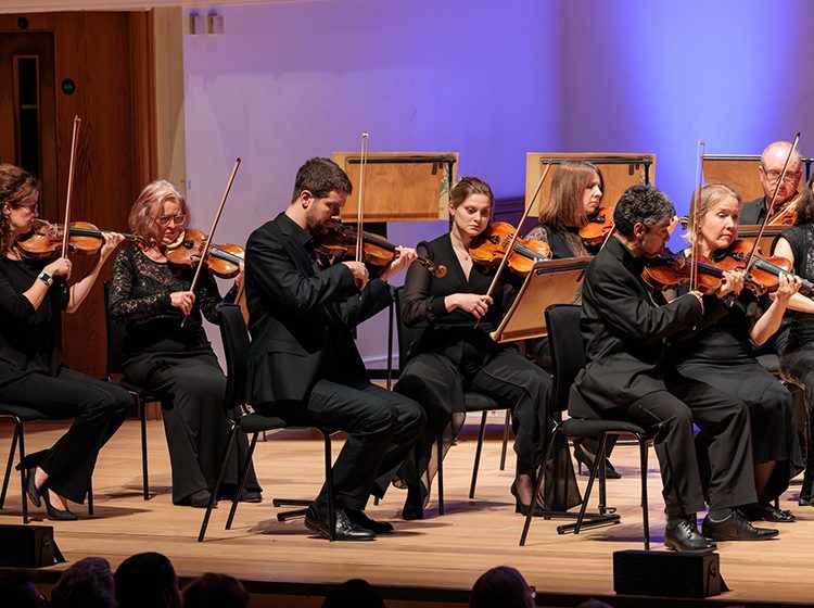 Members of the English Chamber Orchestra performing on the stage of Cadogan Hall