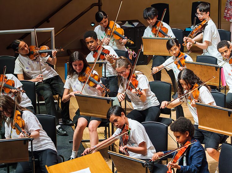 Children playing violins on stage at Cadogan Hall